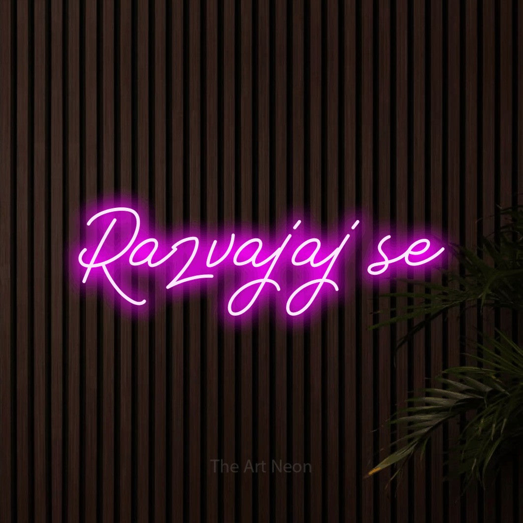 LED neon sign reading “Razvajaj se”, arranged in a single line.