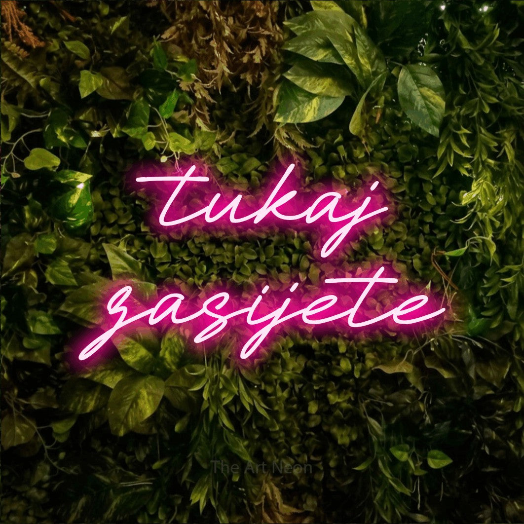LED neon sign reading “tukaj zasijete”, arranged in two lines.
