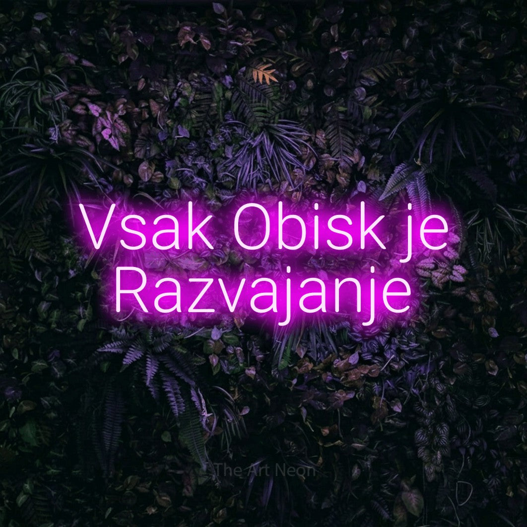 LED neon sign reading “Vsak Obisk je Razvajanje”, arranged in two lines.