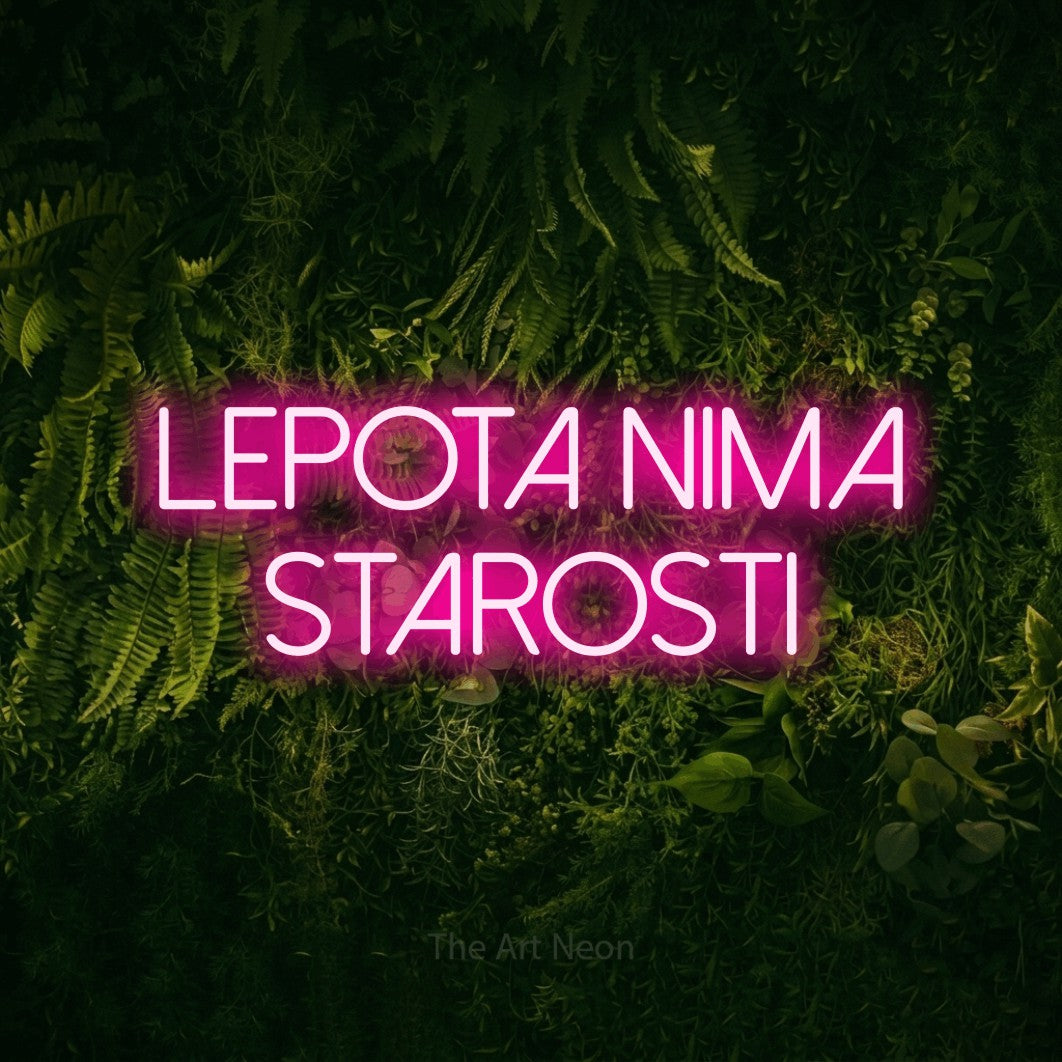 LED neon sign reading “LEPOTA NIMA STAROSTI”, arranged in two lines.