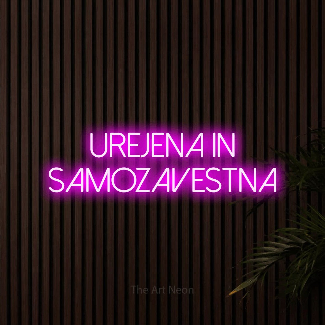LED neon sign reading “Urejena in Samozavestna”, arranged in two lines.