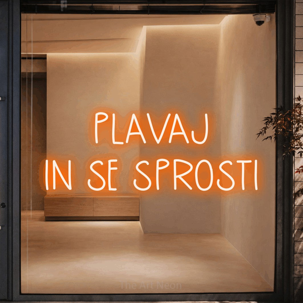 LED neon sign reading “PLAVAJ IN SE SPROSTI”, arranged in two lines.
