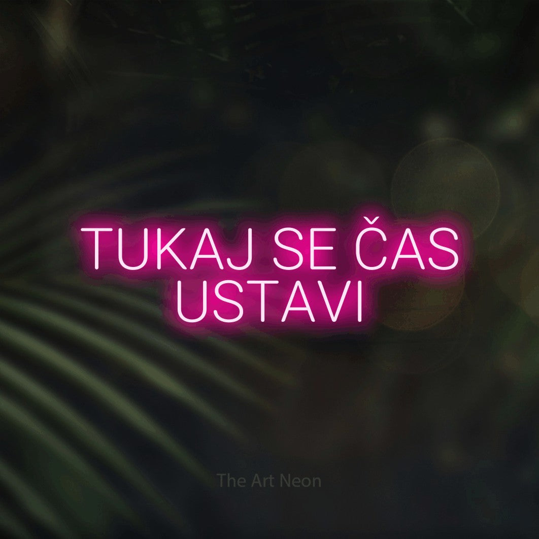LED neon sign reading “TUKAJ SE ČAS USTAVI”, arranged in two lines.