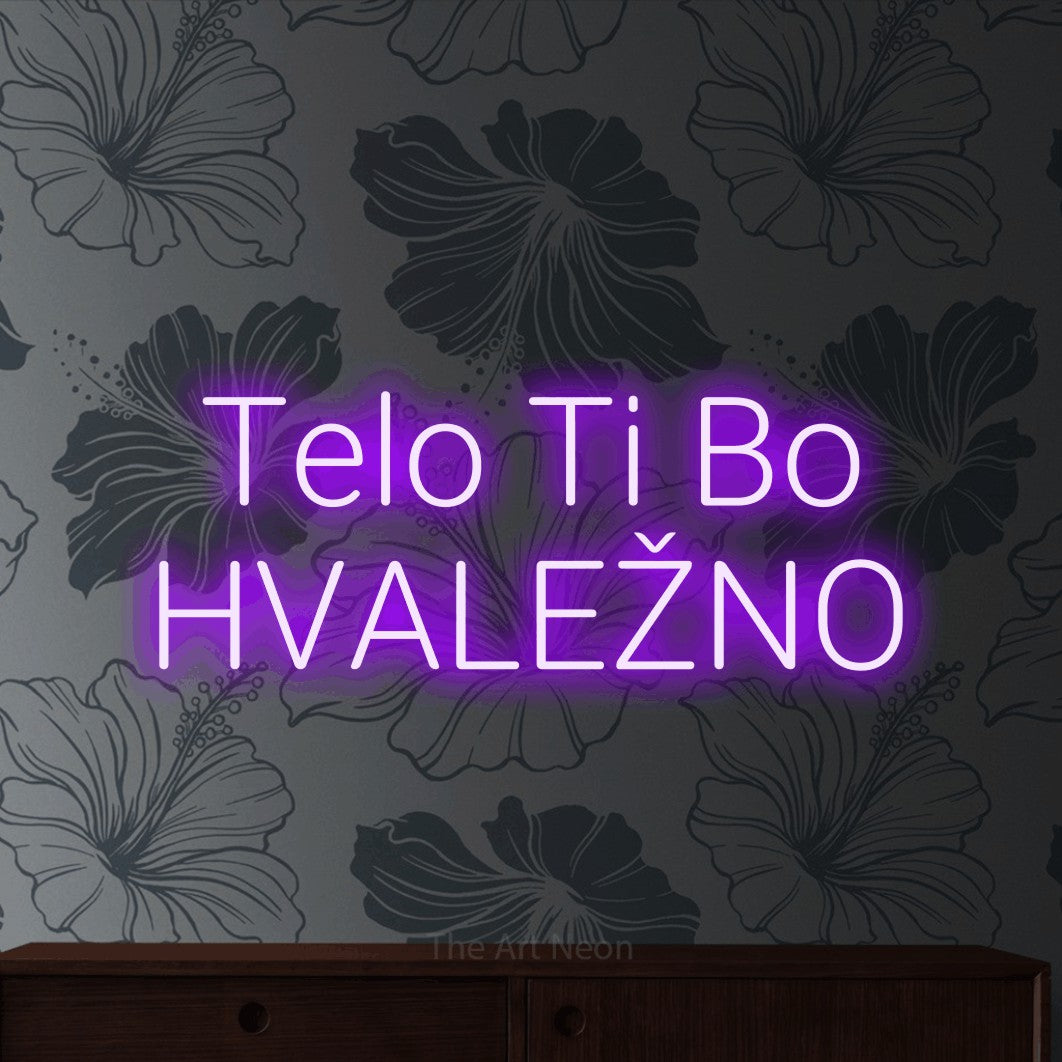 LED neon sign reading “Telo Ti Bo HVALEŽNO”, arranged in two lines.