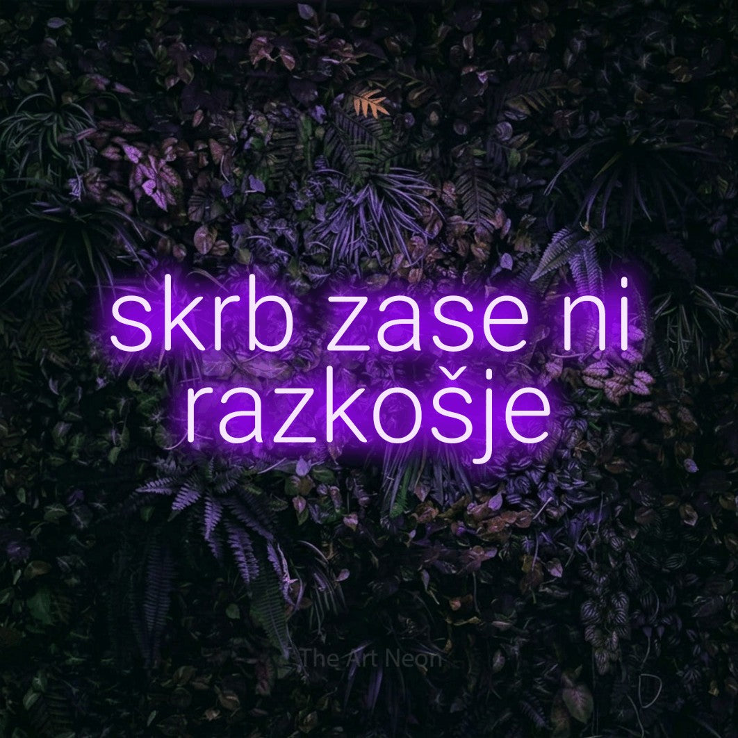 LED neon sign reading “skrb zase ni razkošje”, arranged in two lines.