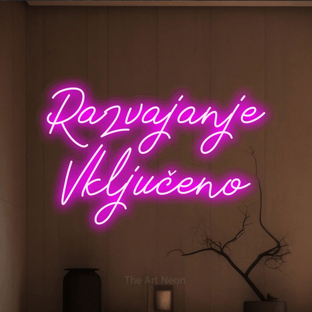 LED neon sign reading “Razvajanje Vključeno”, arranged in two lines.