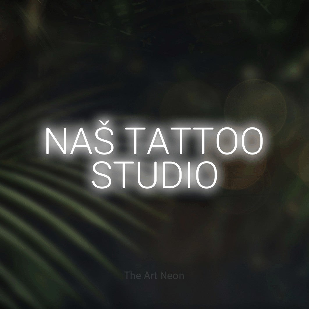 LED neon sign reading “NAŠ TATTOO STUDIO”, arranged in two lines.