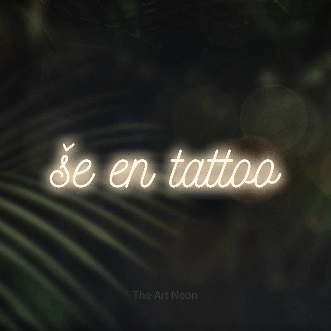 LED neon sign reading “še en tattoo”, arranged in a single line.