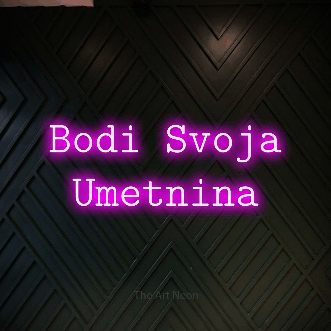 LED neon sign reading “Bodi Svoja Umetnina”, arranged in two lines.