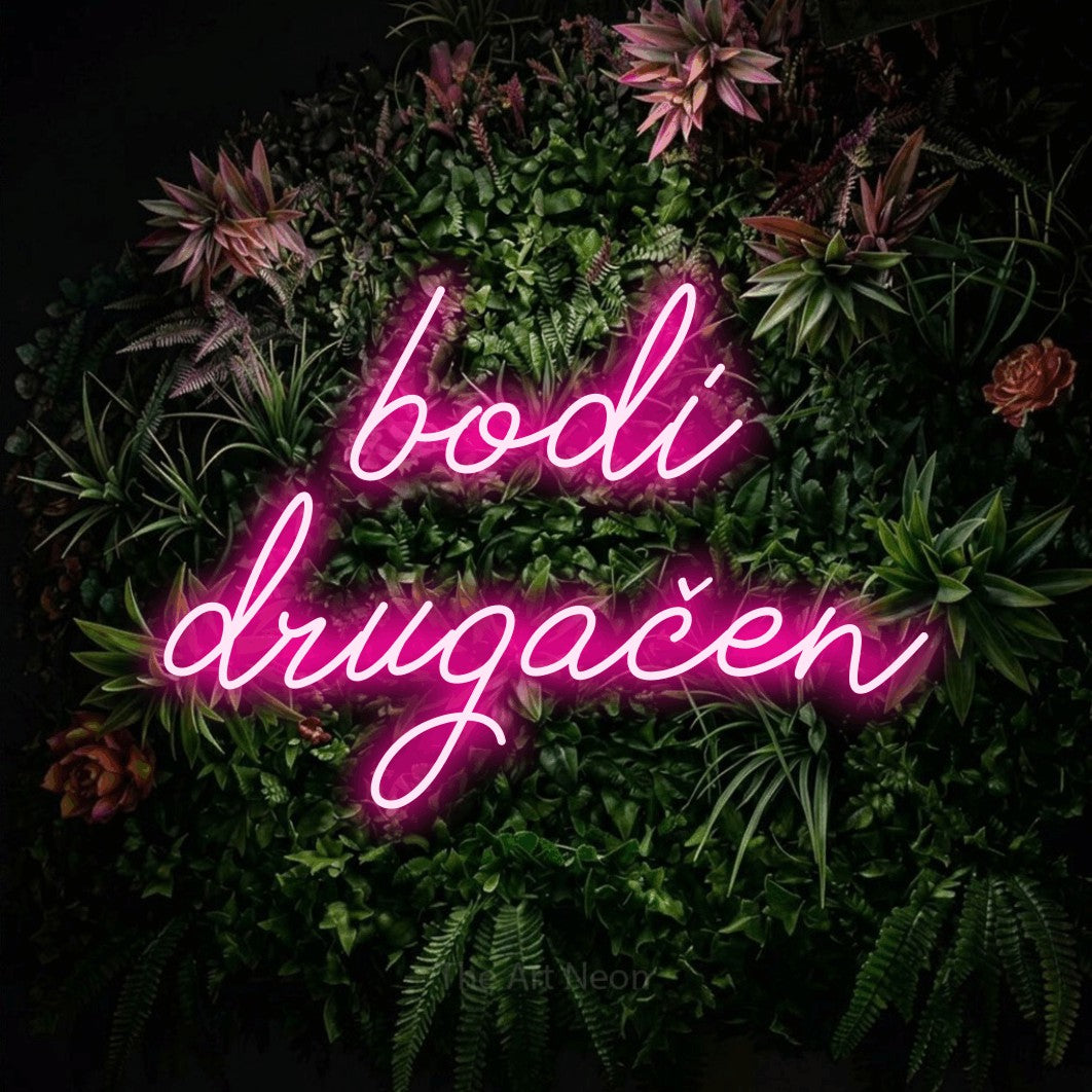 LED neon sign reading “bodi drugačen”, arranged in two lines.