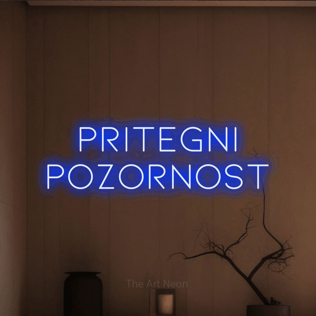 LED neon sign reading “pritegni pozornost”, arranged in two lines.