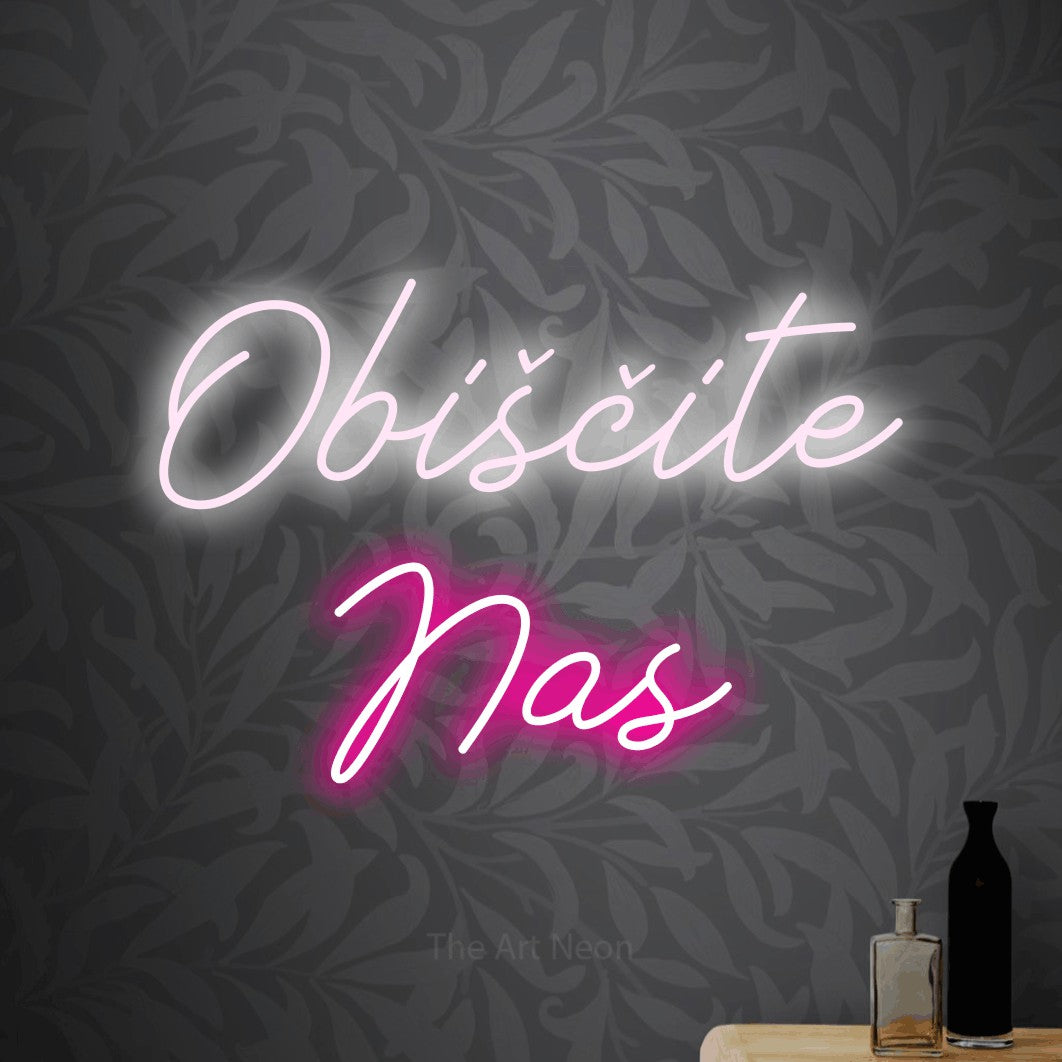 LED neon sign reading “Obiščite Nas”, arranged in two lines.