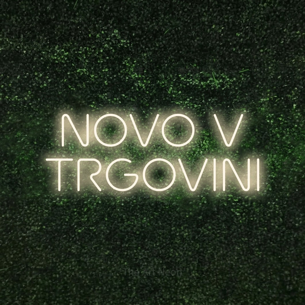 LED neon sign reading “NOVO V TRGOVINI”, arranged in two lines.