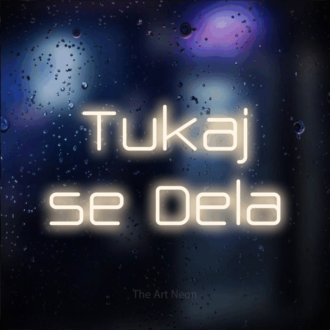 LED neon sign reading “Tukaj se Dela”, arranged in two lines.