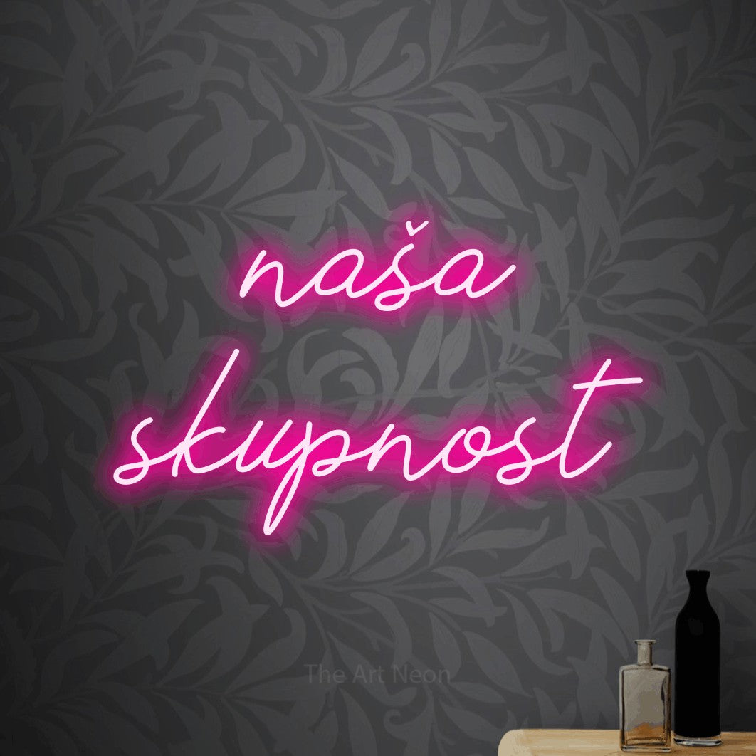 LED neon sign reading “naša skupnost”, arranged in two lines.