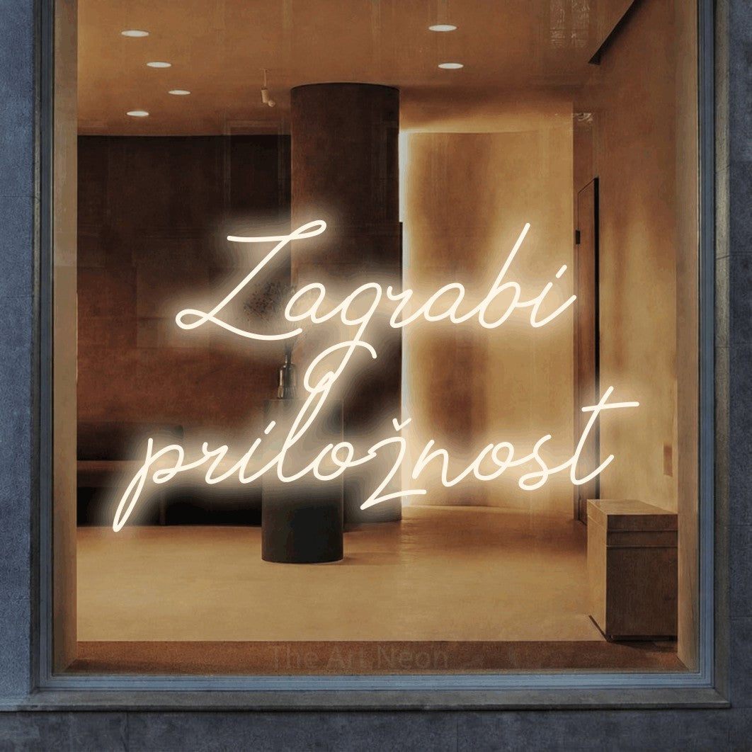 LED neon sign reading “Zagrabi priložnost”, arranged in two lines.