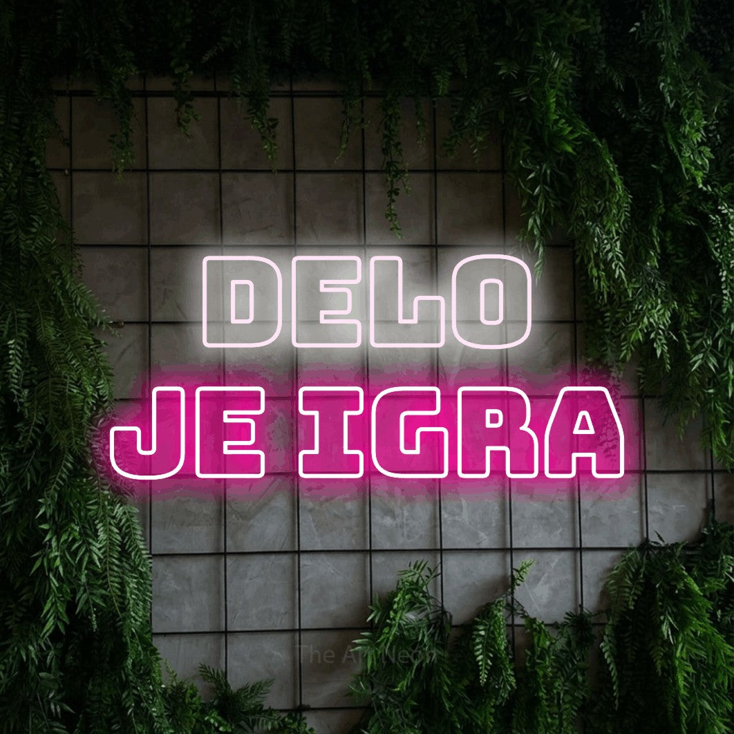 LED neon sign reading “Delo je Igra”, arranged in two lines.