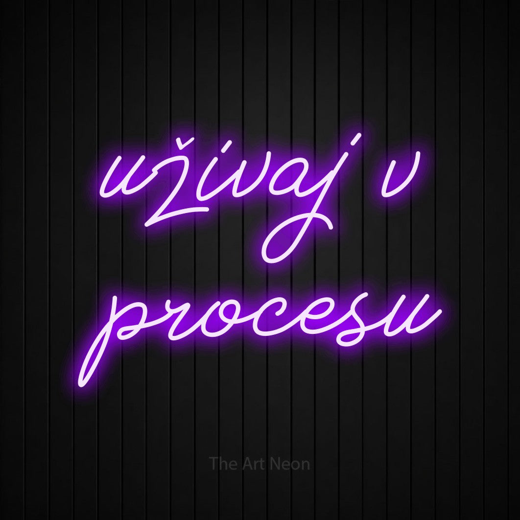 LED neon sign reading “uživaj v procesu”, arranged in two lines.