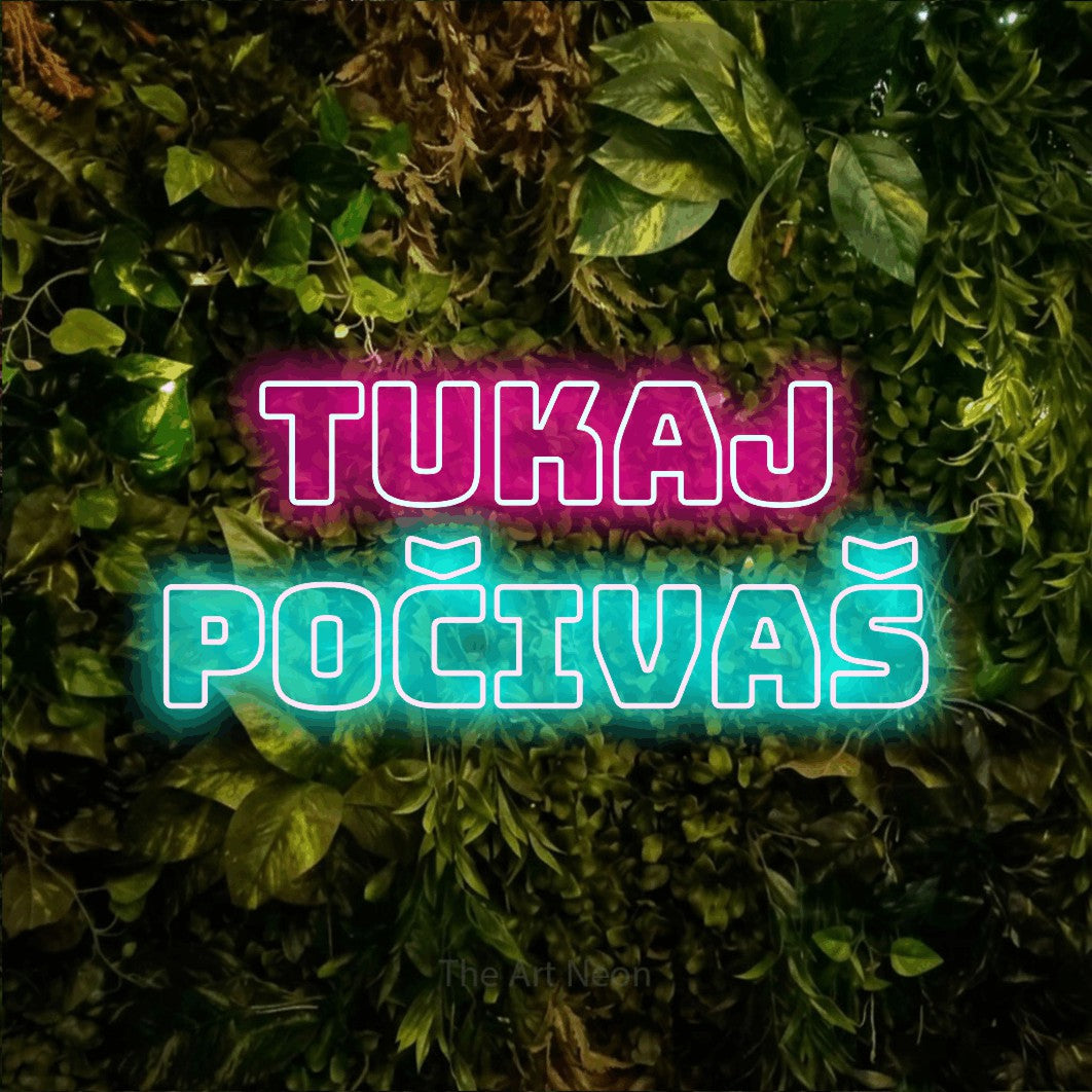 LED neon sign reading “tukaj počivaš”, arranged in two lines.