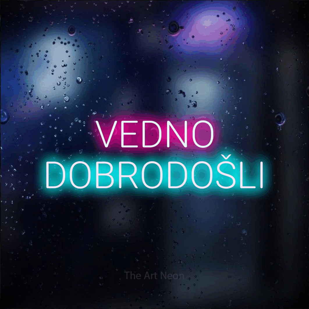LED neon sign reading “VEDNO DOBRODOŠLI”, arranged in two lines.
