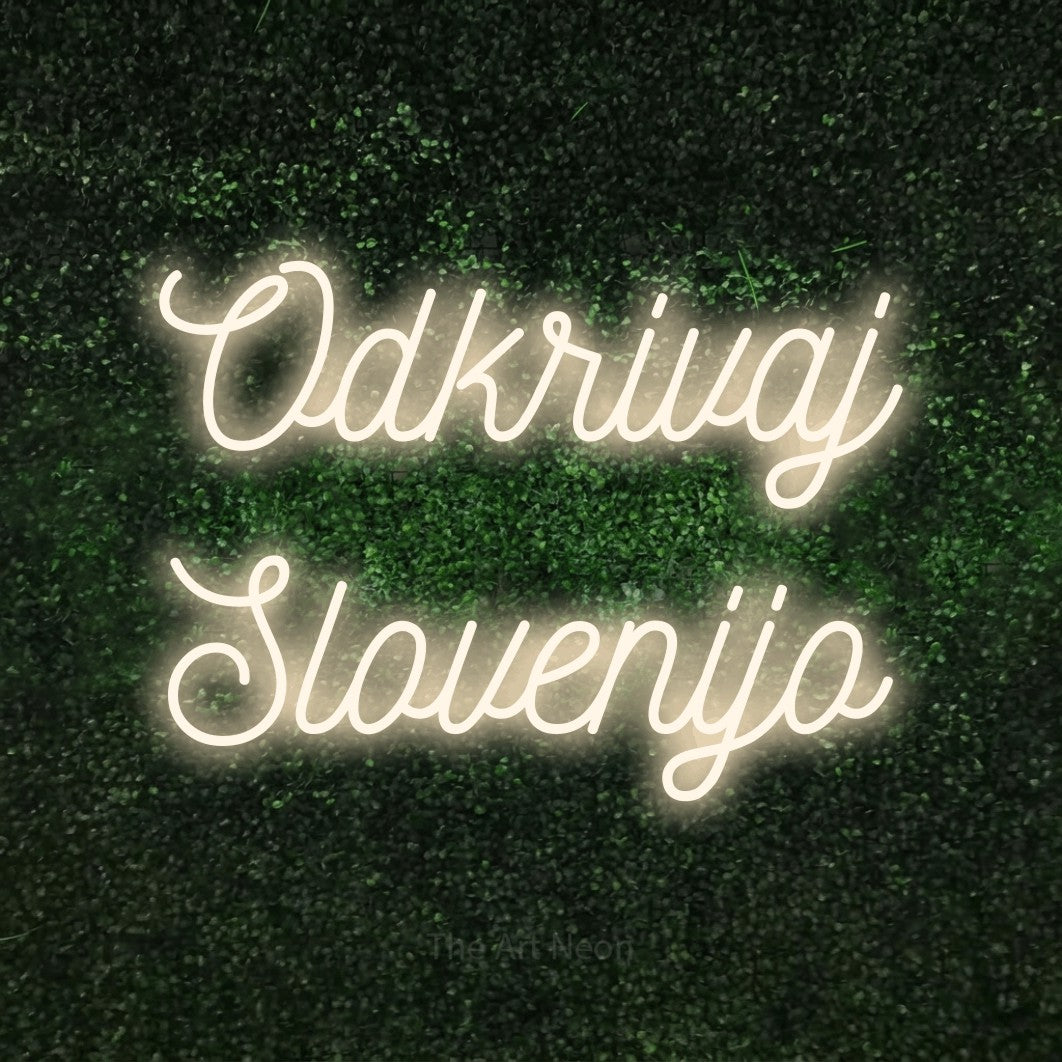 LED neon sign reading “Odkrivaj Slovenijo”, arranged in two lines.