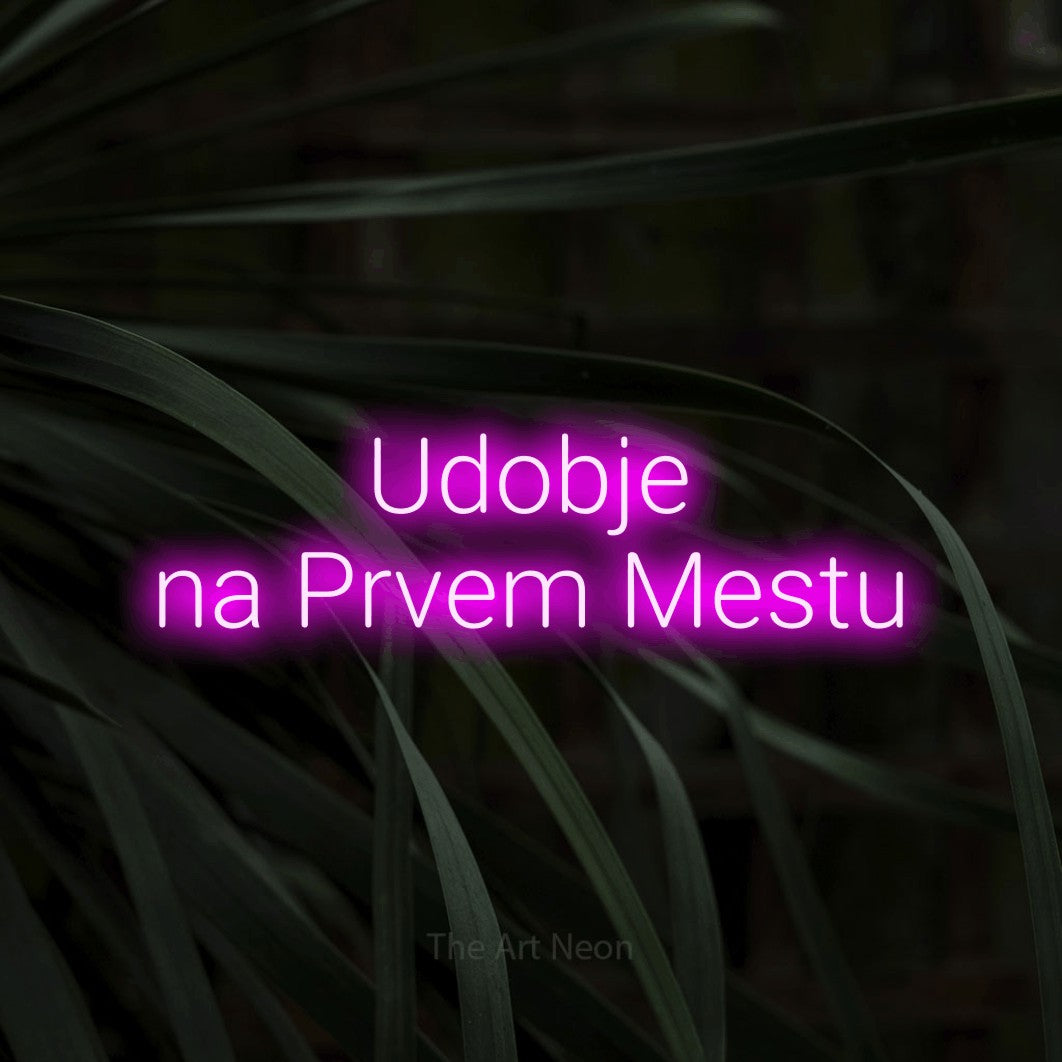 LED neon sign reading “Udobje na Prvem Mestu”, arranged in two lines.