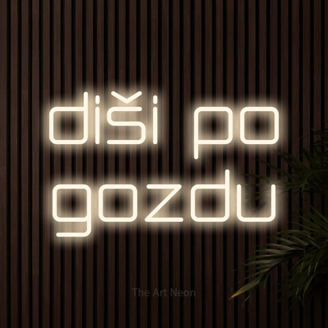 LED neon sign reading “diši po gozdu”, arranged in two lines.
