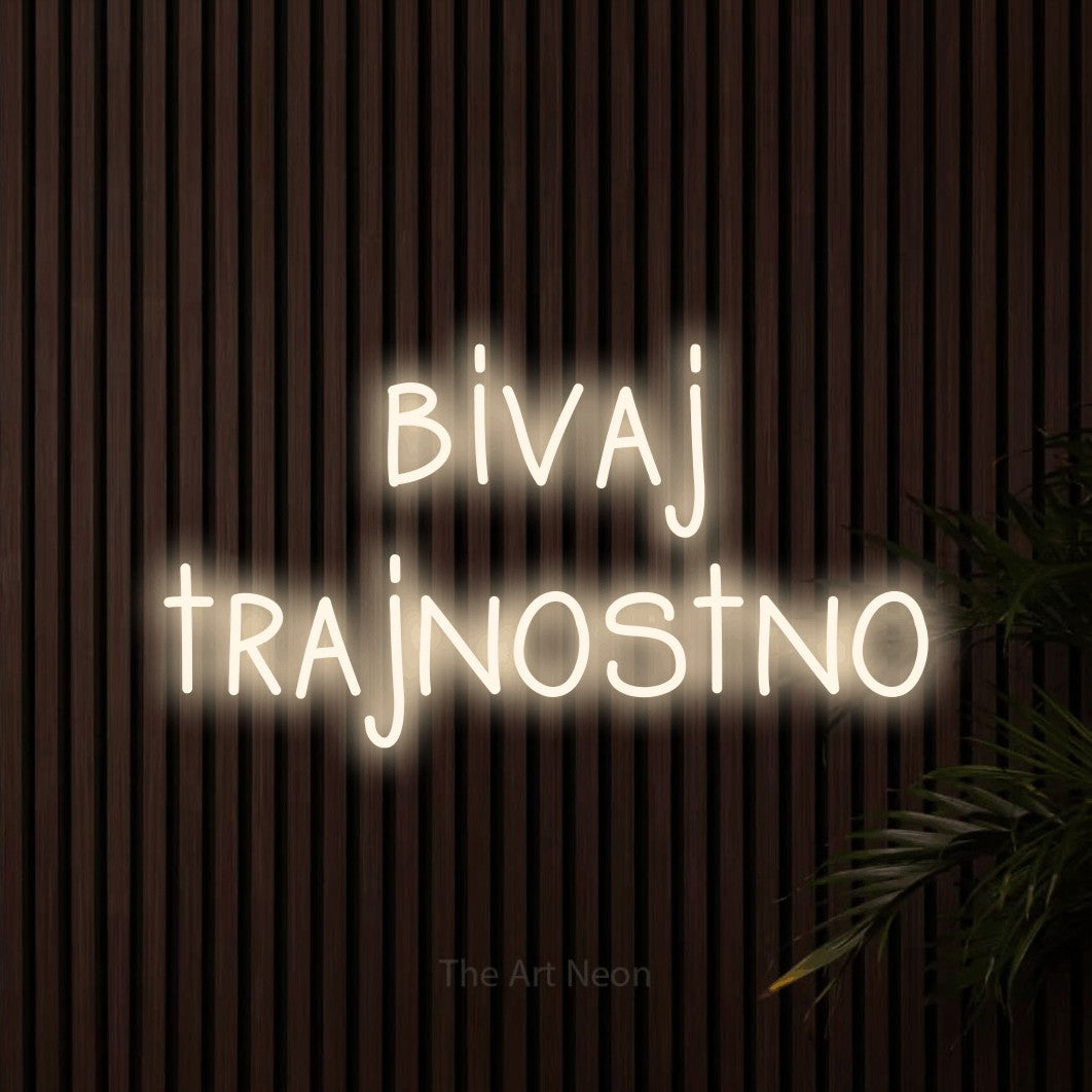 LED neon sign reading “bivaj trajnostno”, arranged in two lines.