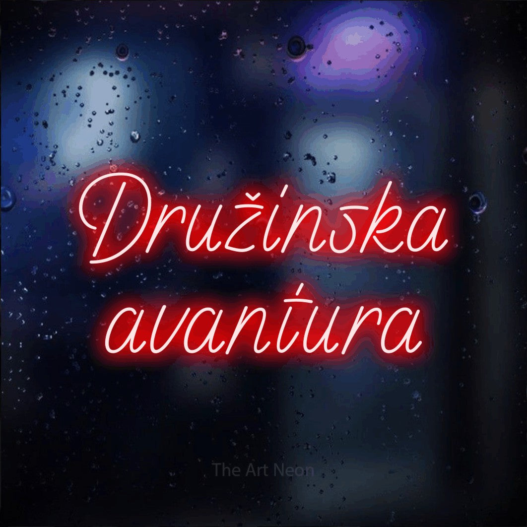 LED neon sign reading “Družinska avantura”, arranged in two lines.