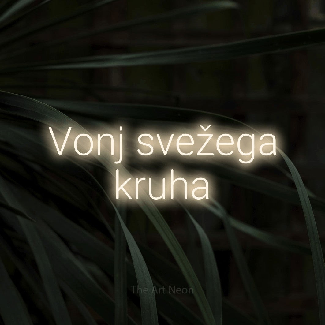 LED neon sign reading “Vonj svežega kruha”, arranged in two lines.