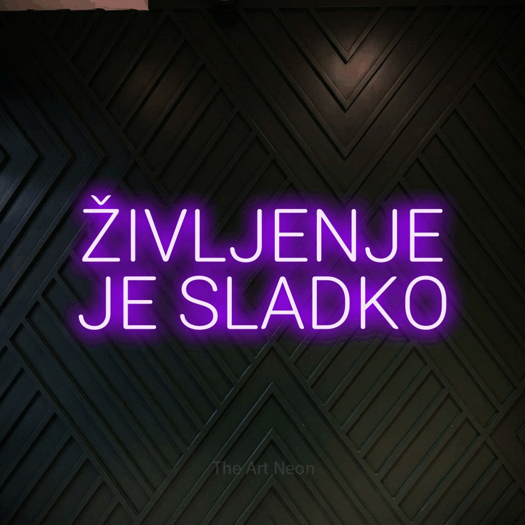 LED neon sign reading “ŽIVLJENJE JE SLADKO”, arranged in two lines.