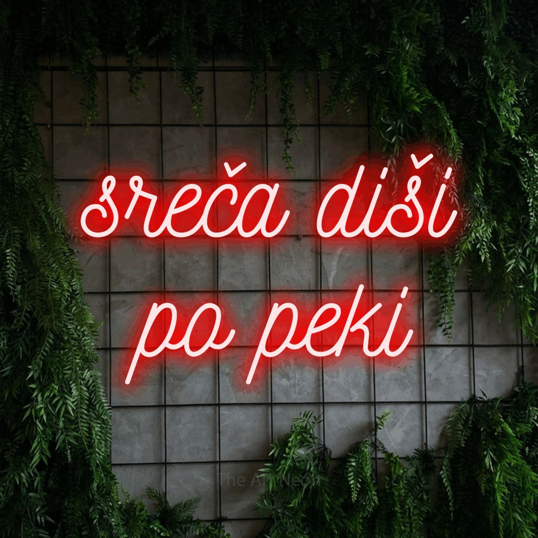 LED neon sign reading “sreča diši po peki”, arranged in two lines.