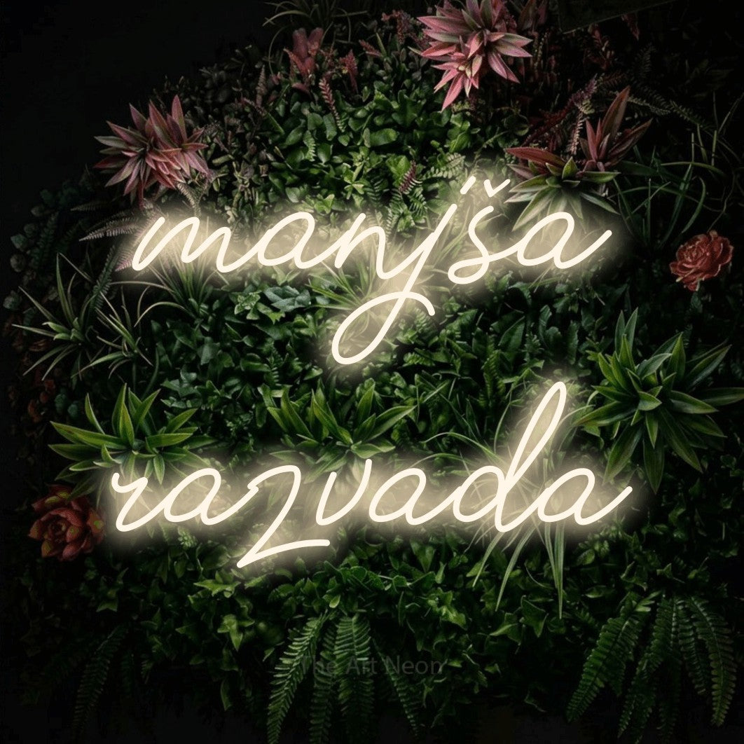 LED neon sign reading “manjša razvada”, arranged in two lines.