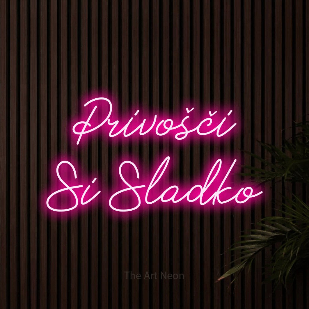 LED neon sign reading “Privošči Si Sladko”, arranged in two lines.