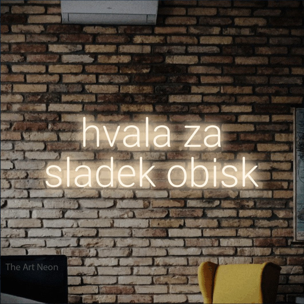 LED neon sign reading “hvala za sladek obisk”, arranged in two lines.