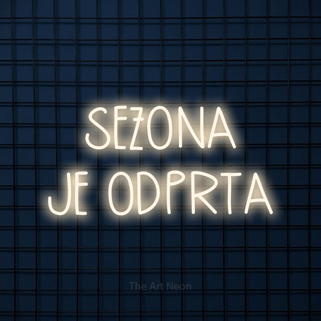 LED neon sign reading “SEZONA JE ODPRTA”, arranged in two lines.