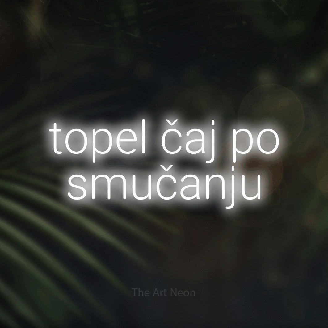 LED neon sign reading “topel čaj po smučanju”, arranged in two lines.