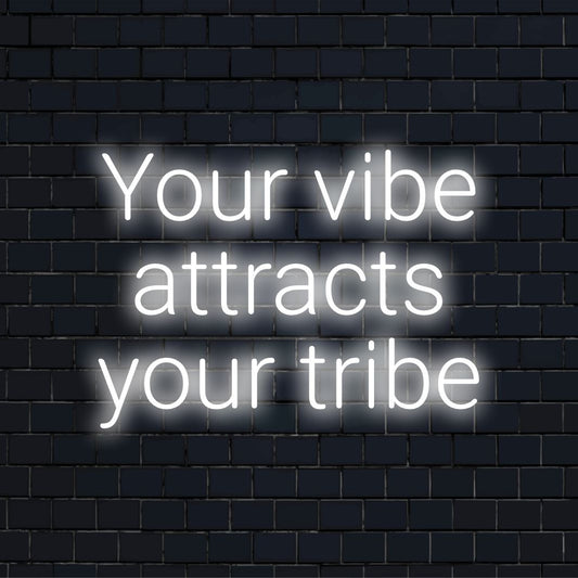 Vibrant neon sign reads Your Vibe Attracts Your Tribe in stylish LED letters, perfect for wall art and modern decor.