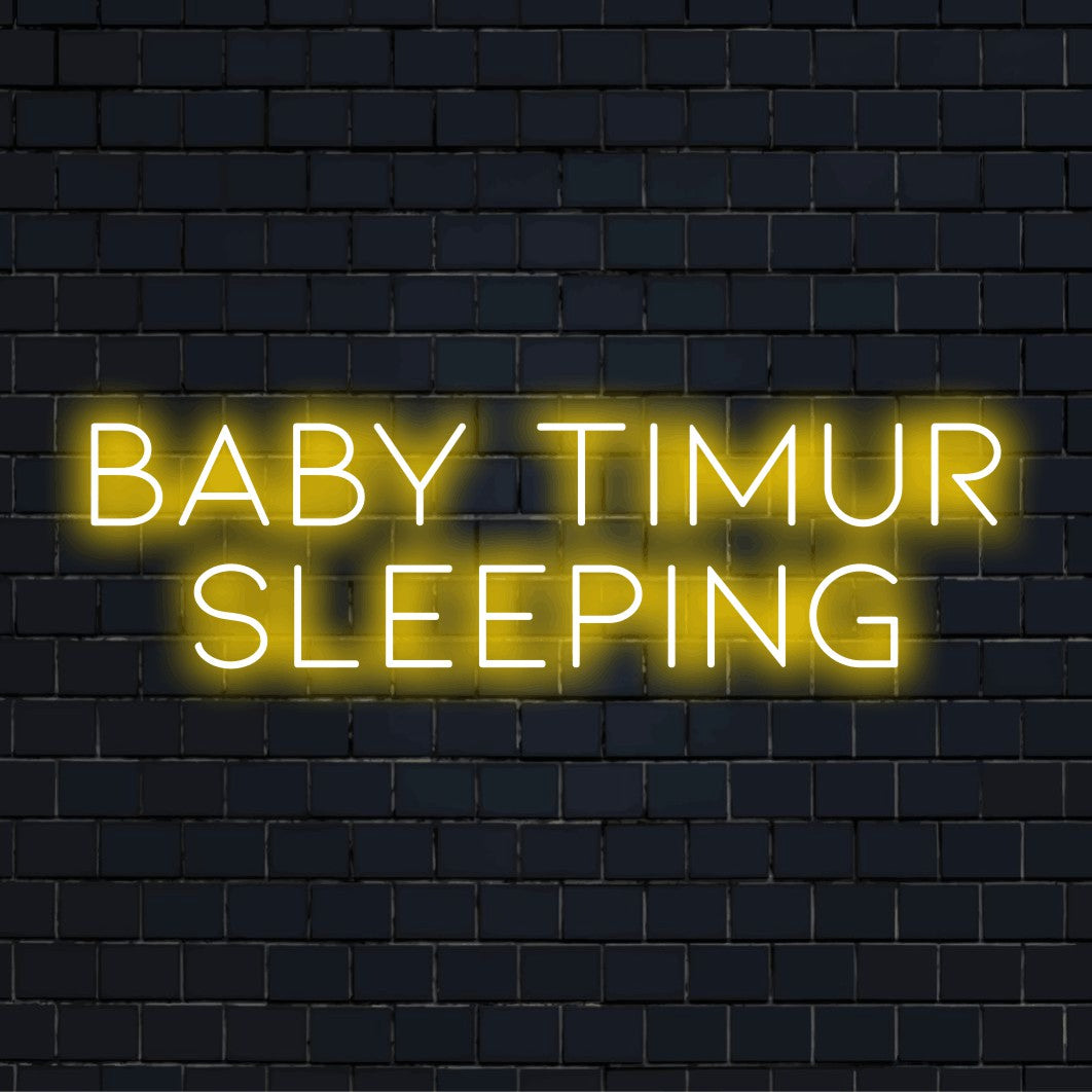 Baby Timur Sleeping Custom Name Neon Sign, bright neon glow against brick backdrop