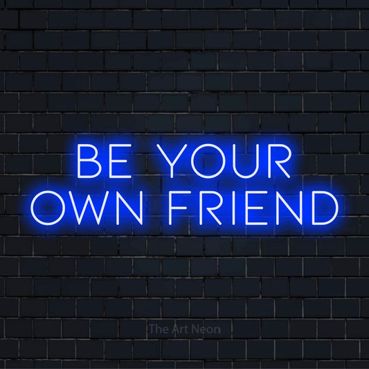 "Be Your Own Friend" neon text design on a black brick wall