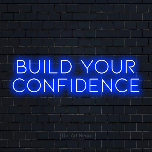 "Build Your Confidence" LED neon sign on a black brick wall