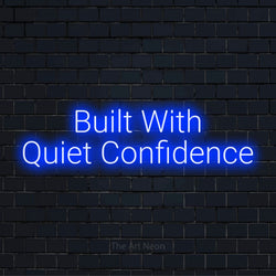 "Built With Quiet Confidence" glowing LED neon sign on a black brick wall