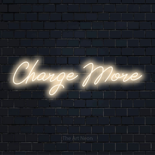 "Charge More" glowing LED neon sign on a black brick wall