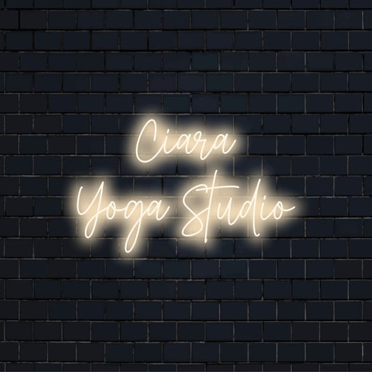 Ciara Yoga Studio Custom Name Neon Sign, bright neon lettering on black brick background