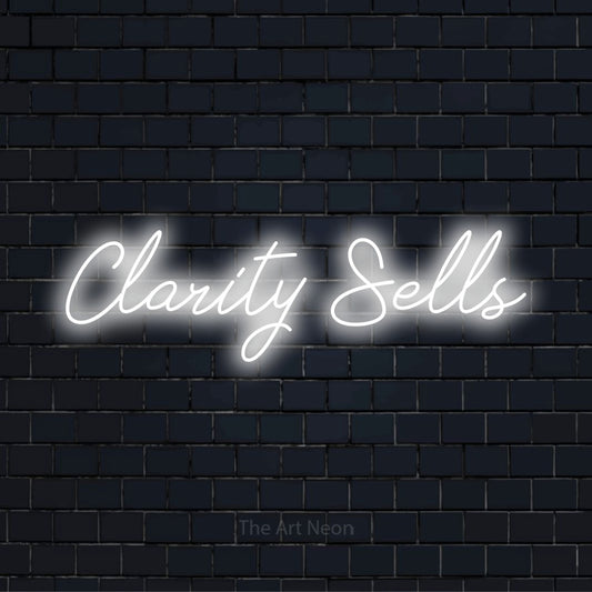 "Clarity Sells" neon text design on a black brick wall