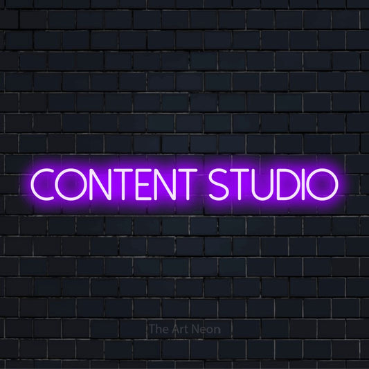 "Content Studio" script-style LED neon sign on a black brick wall