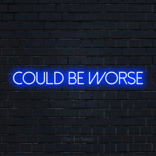"Could Be Worse" LED neon sign on a black brick wall