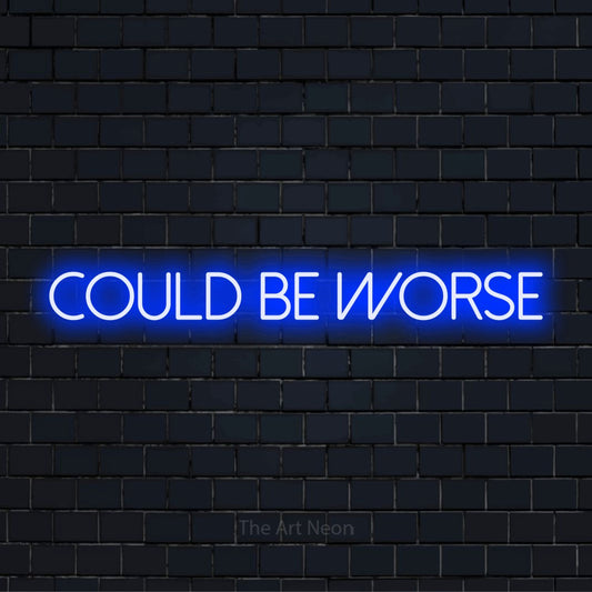 "Could Be Worse" LED neon sign on a black brick wall