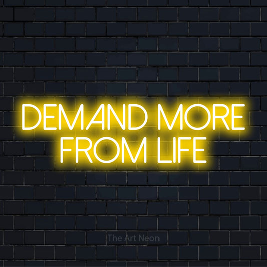 "Demand More From Life" neon text design on a black brick wall