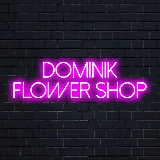 Dominik Flower Shop Custom Name Neon Sign, bright neon glow against black brick wall